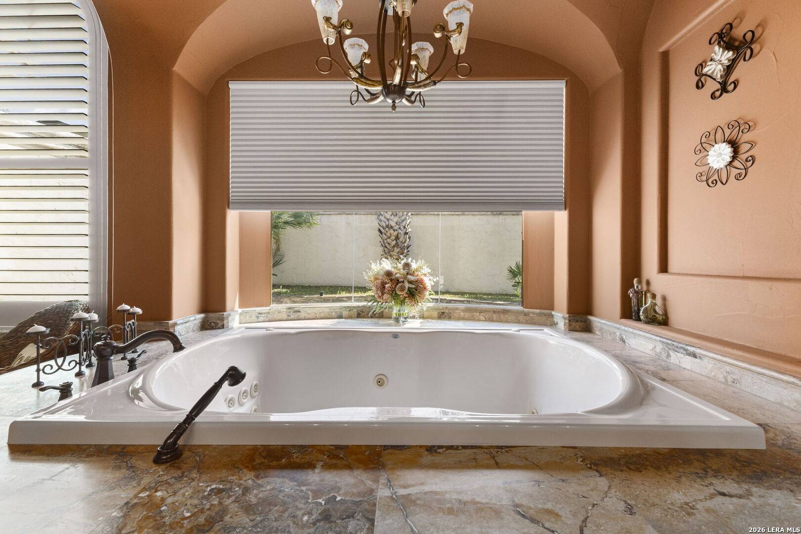 Jetted soaking tub beneath arched windows in the primary bath of 2 Belcourt Place