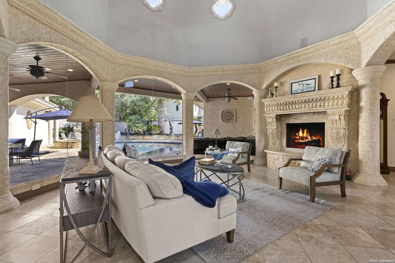 Living room with imported-marble fireplace and glass doors to the pool at 2 Belcourt Place