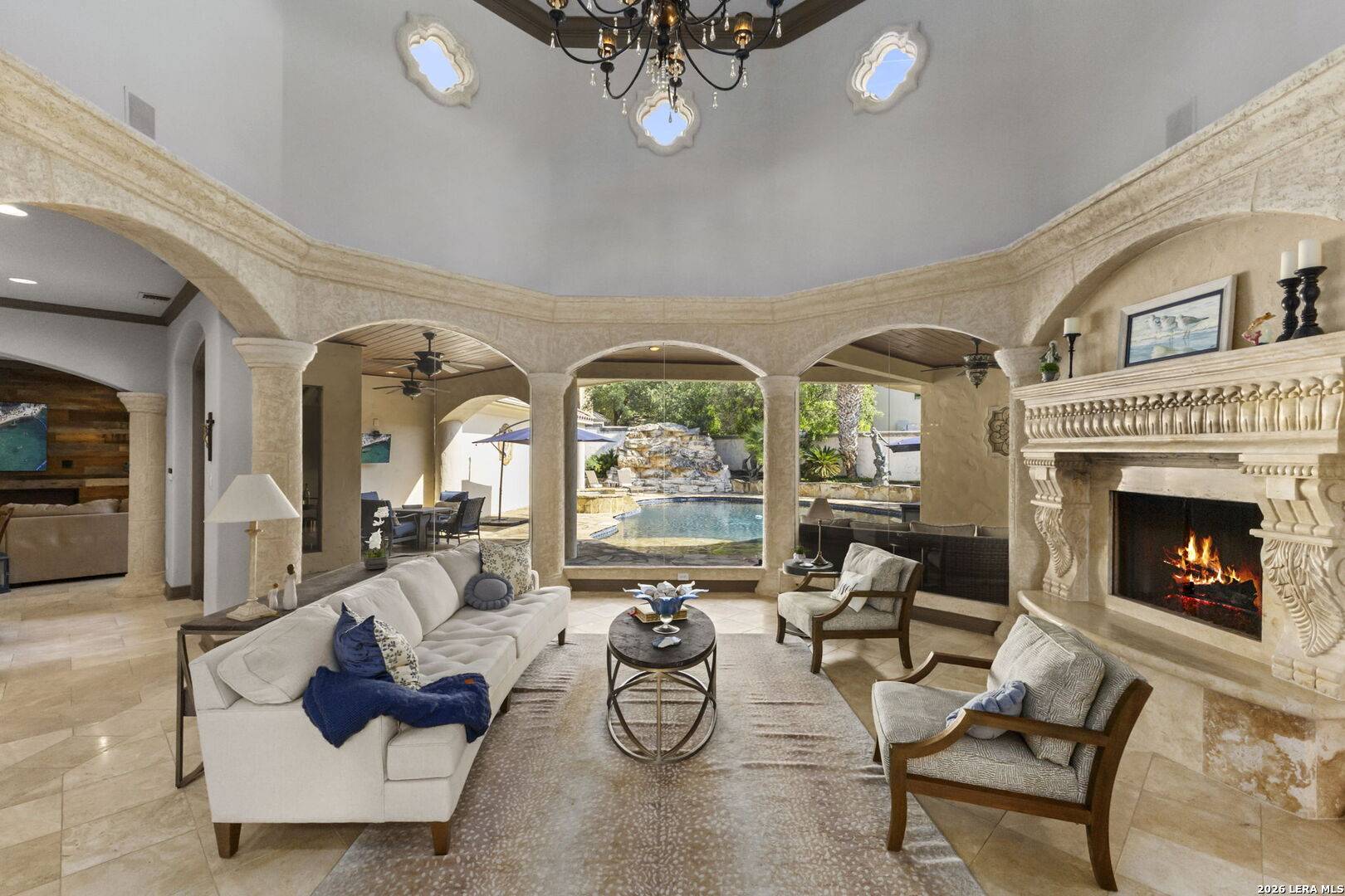 Living room of 2 Belcourt Place looking through walls of glass to the pool and greenbelt