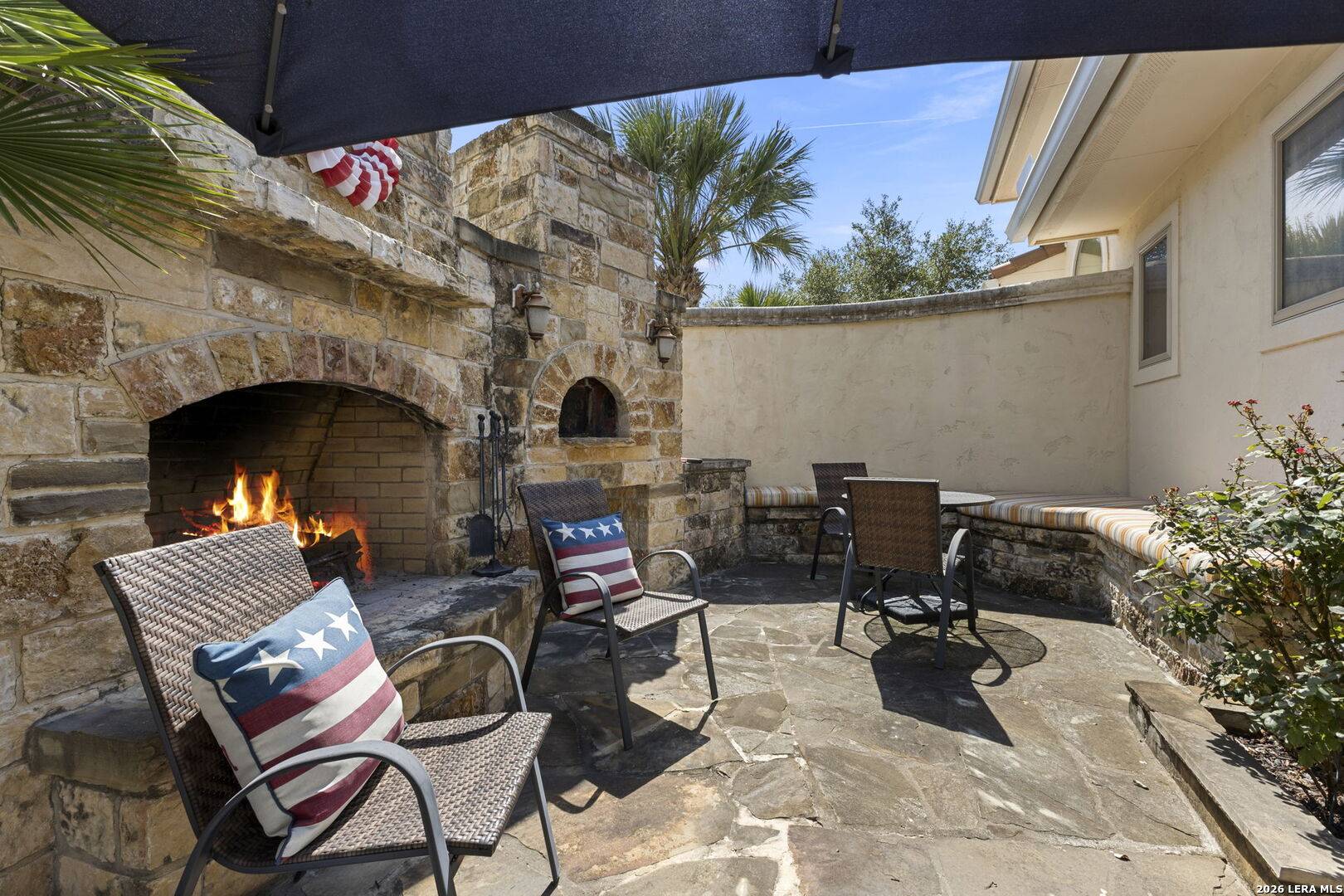 Stone outdoor fireplace and imported Italian brick pizza oven on the terrace at 2 Belcourt Place