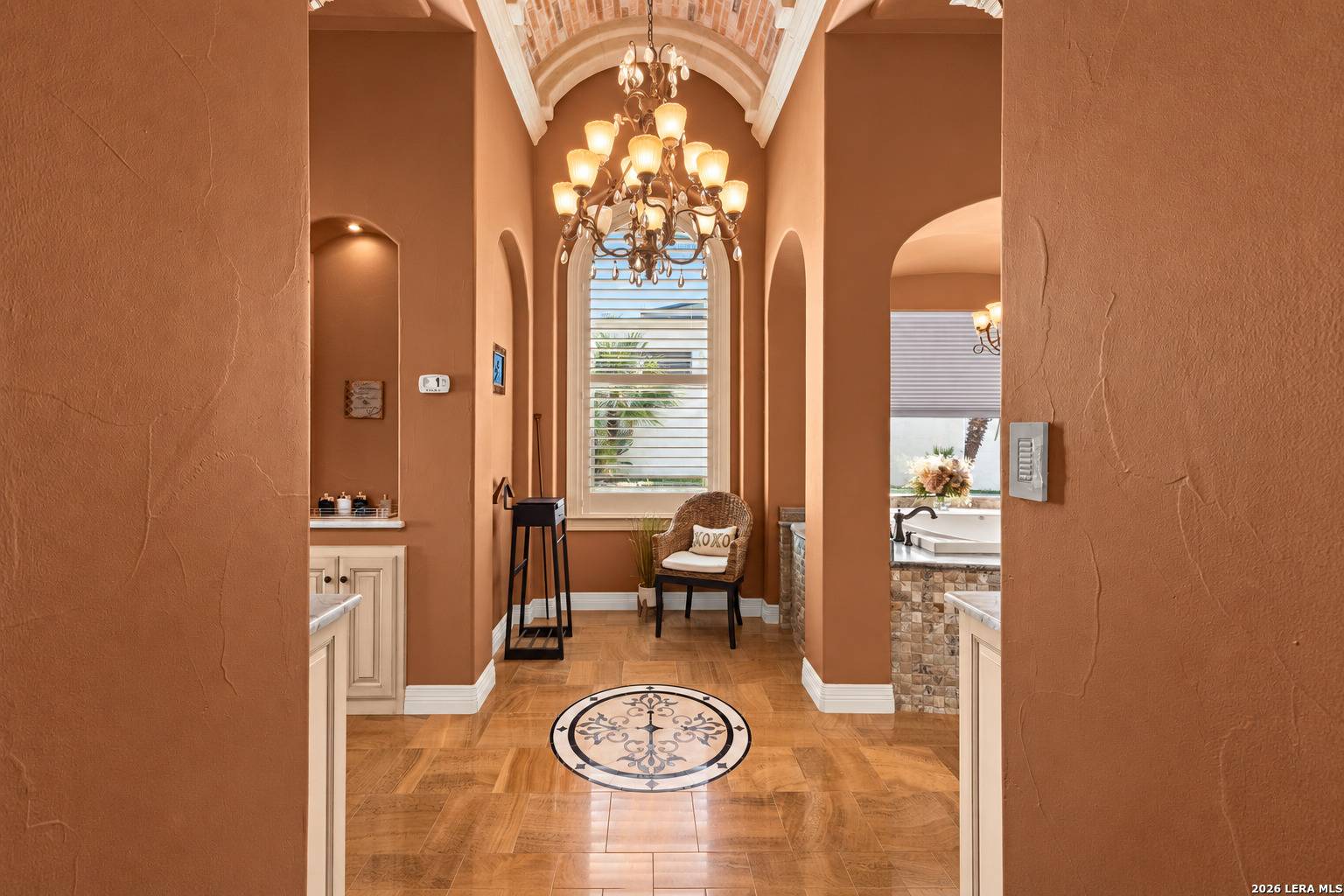 Primary bath at 2 Belcourt Place with vaulted arched ceiling and chandelier