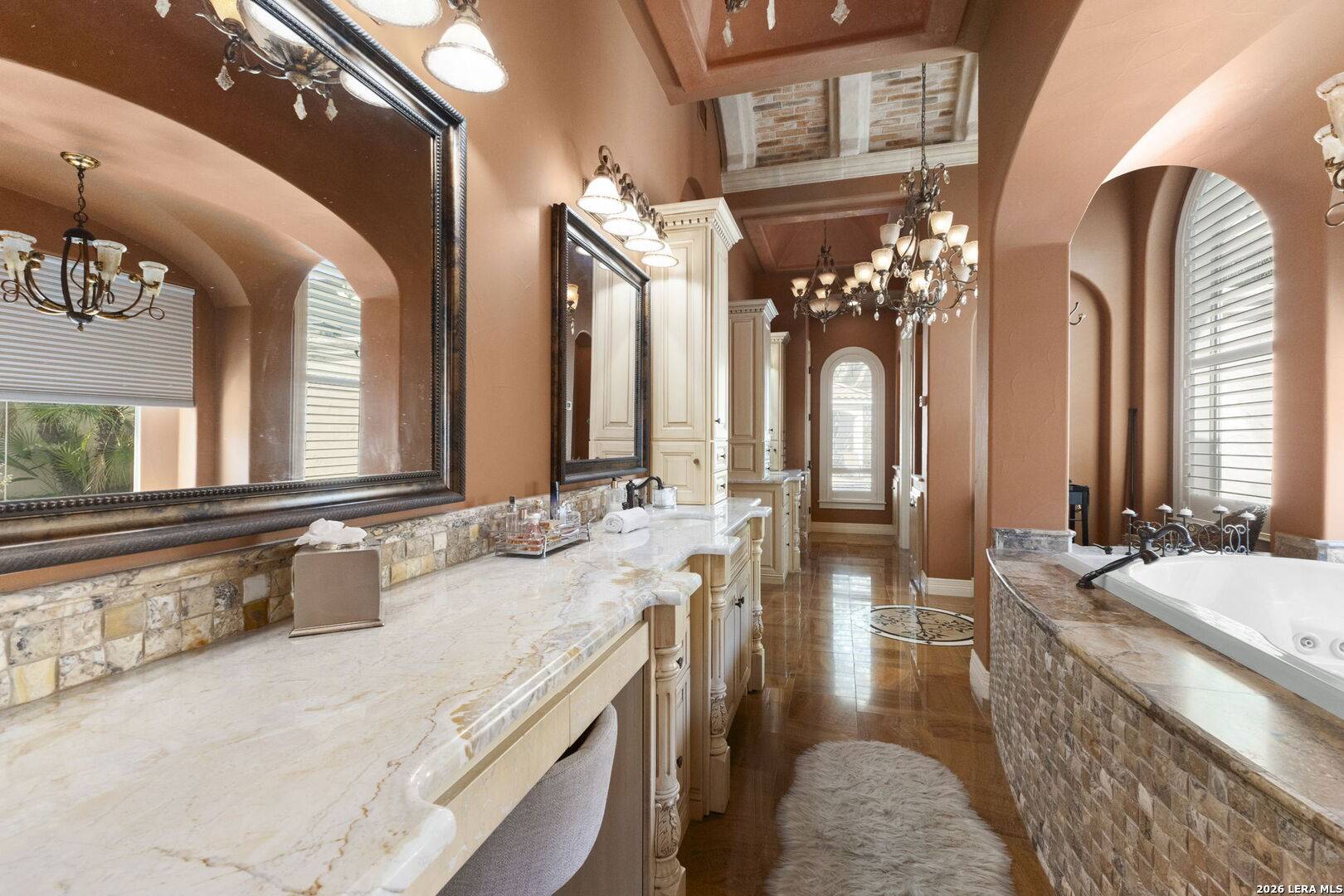 Separate vanities and heated stone floors in the primary bath of 2 Belcourt Place