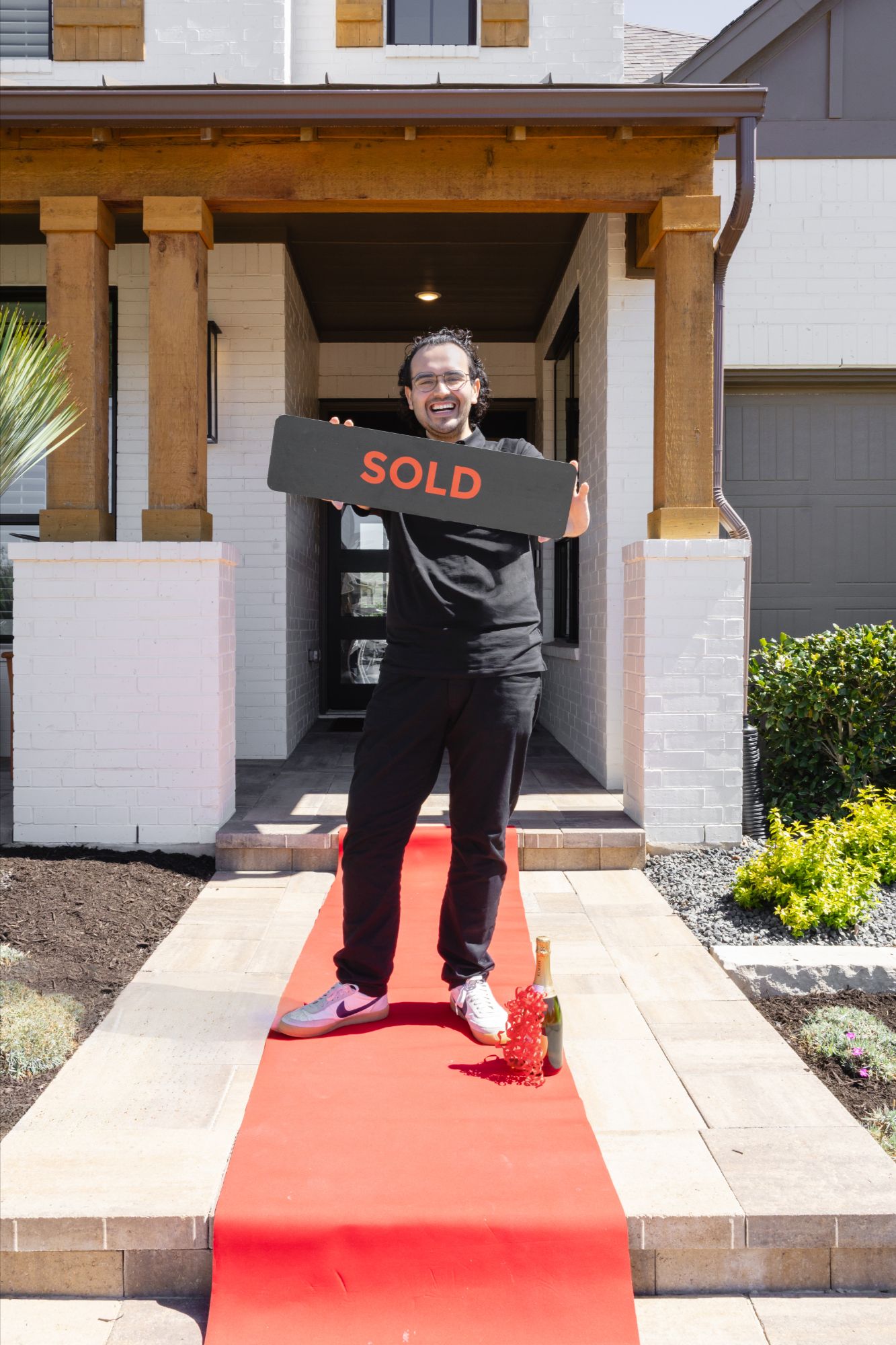 Anthony Sanchez smiling with sold sign