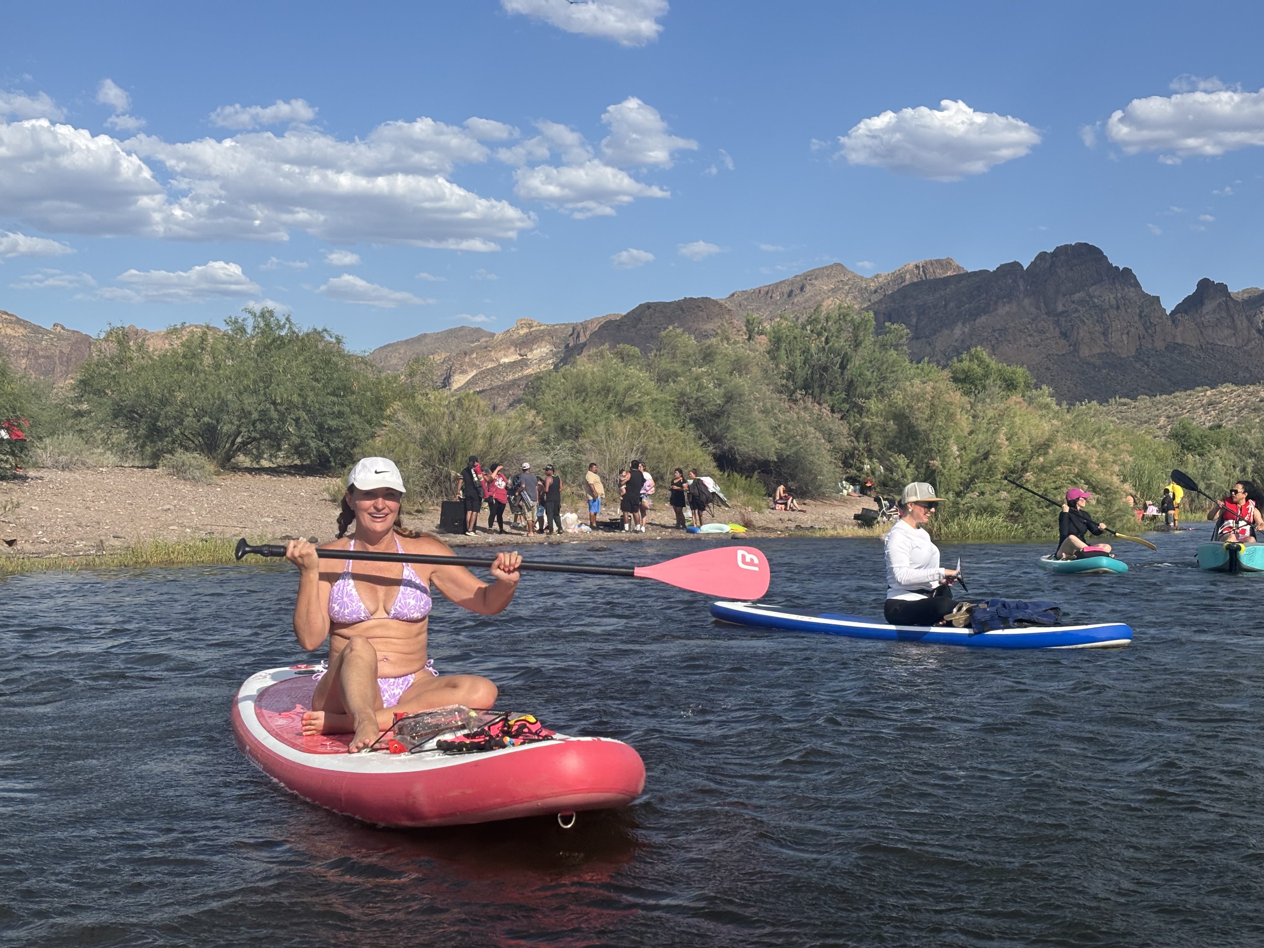 Paddleboarders on the Salt River near Mesa, Arizona with Superstition Mountains in the distance