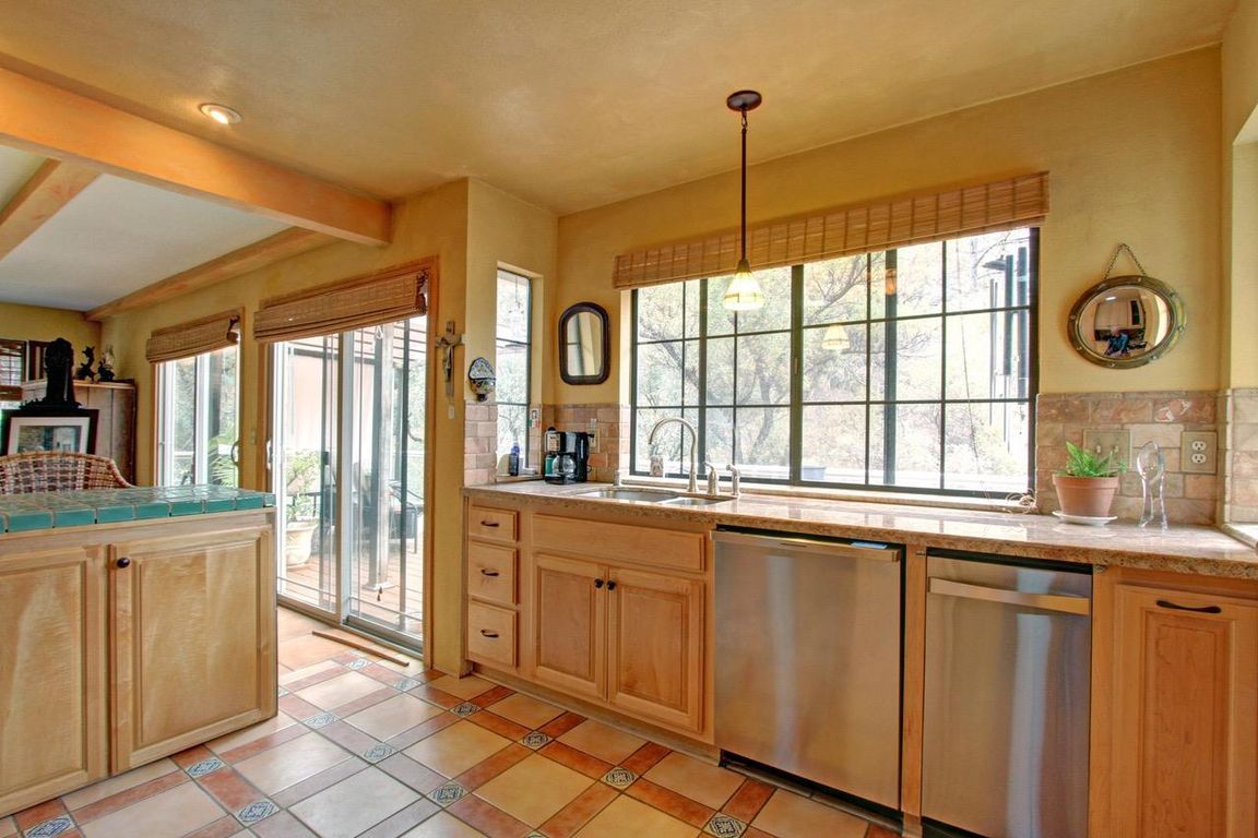 Bright Nevada County kitchen with a large window, stainless appliances, and tile floor