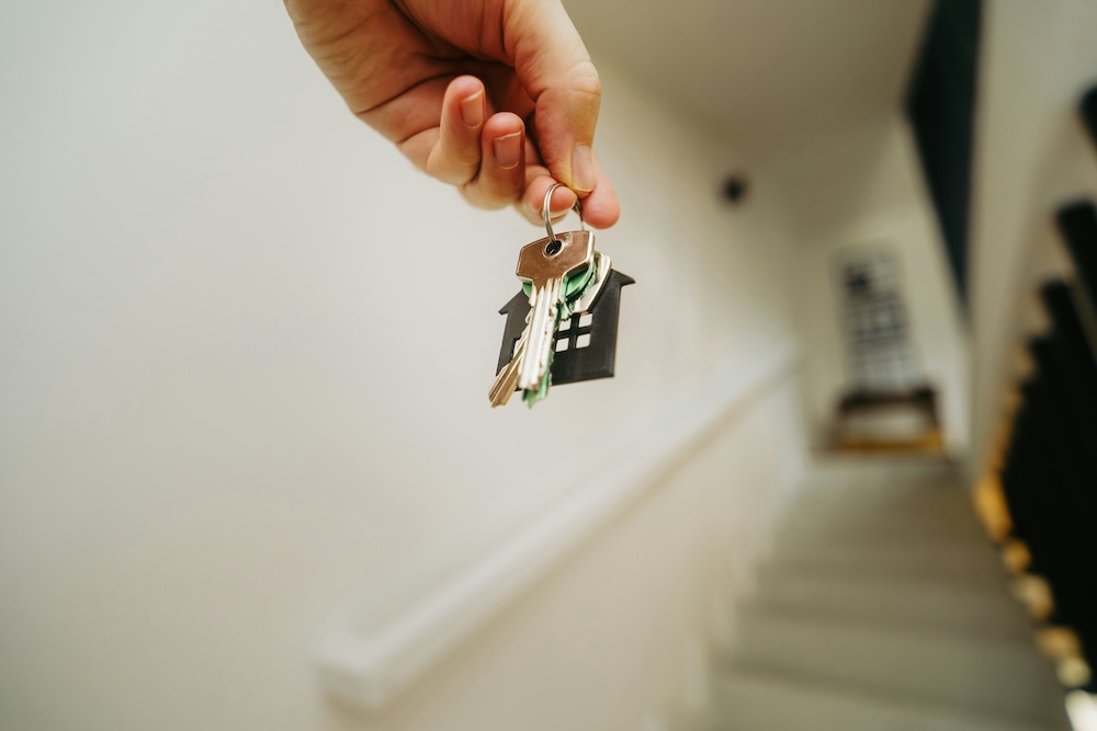 New homeowner holding a house-shaped keychain after closing with a Nevada County agent