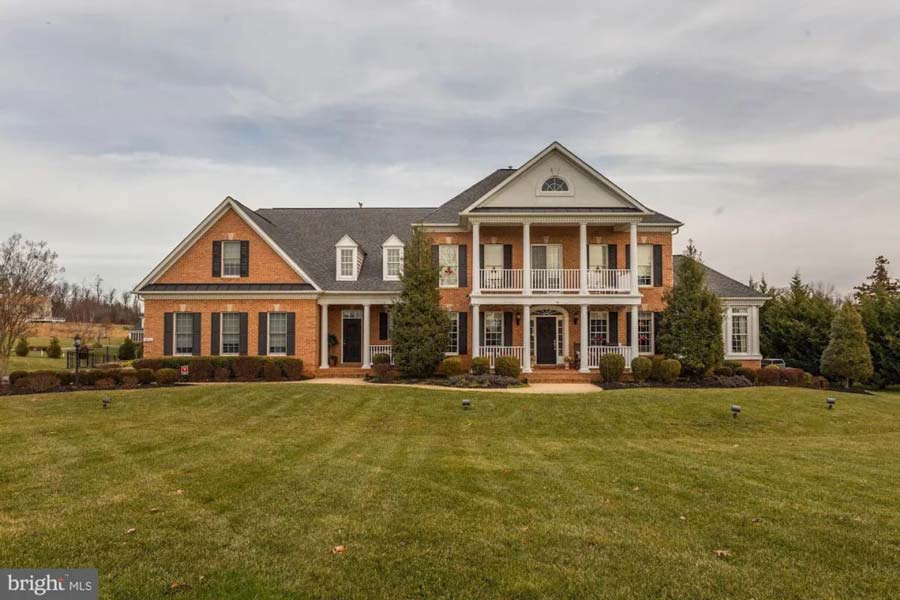 Mansion with brick walls and a large front lawn.