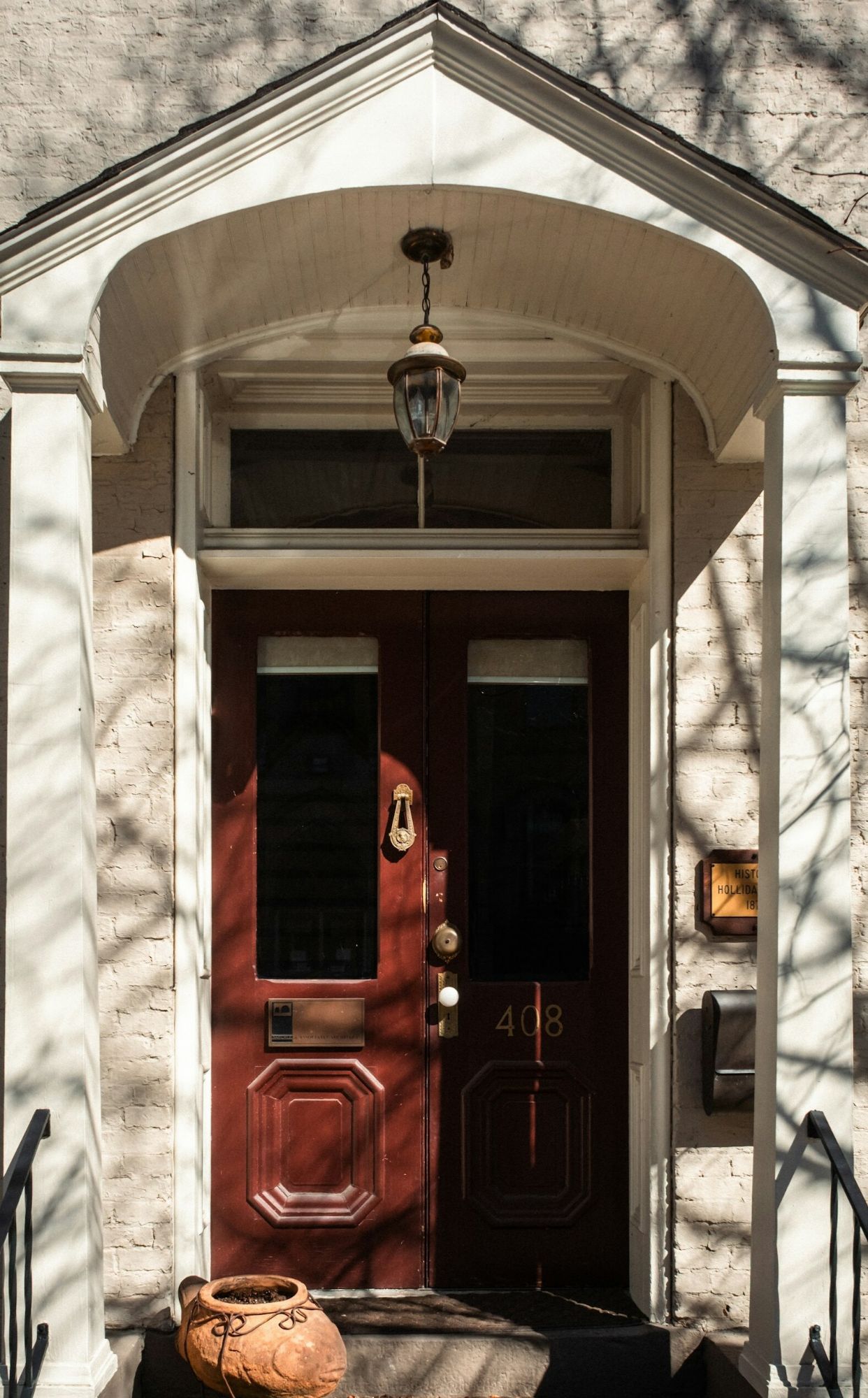 Brown front door with covered roof