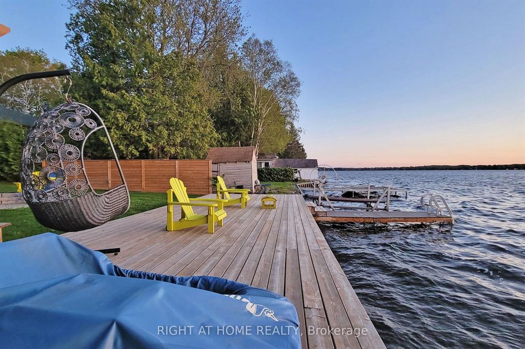 Sunset over a dock and lakeside deck in Kawartha Lakes