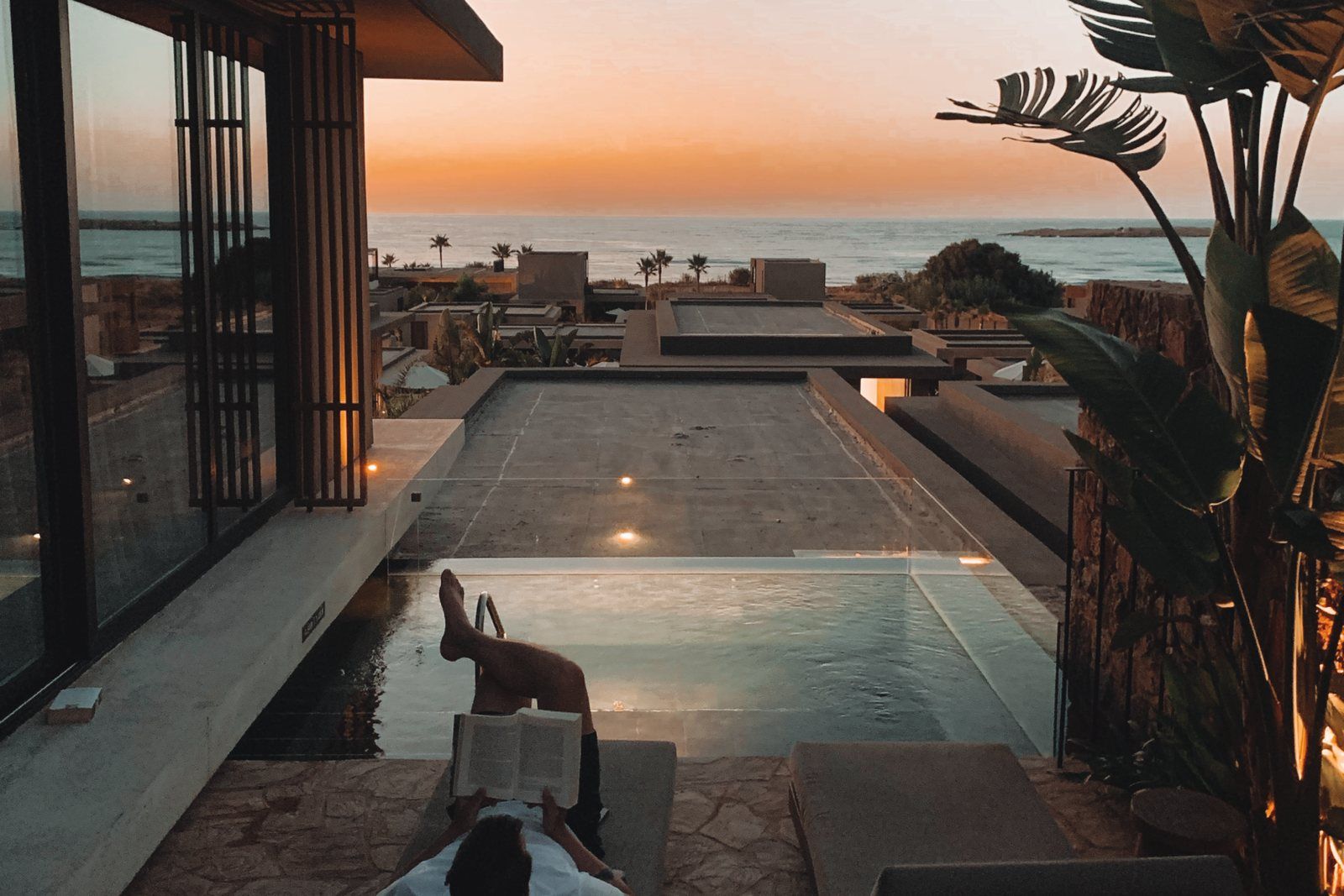 Modern home with a pool at sunset
