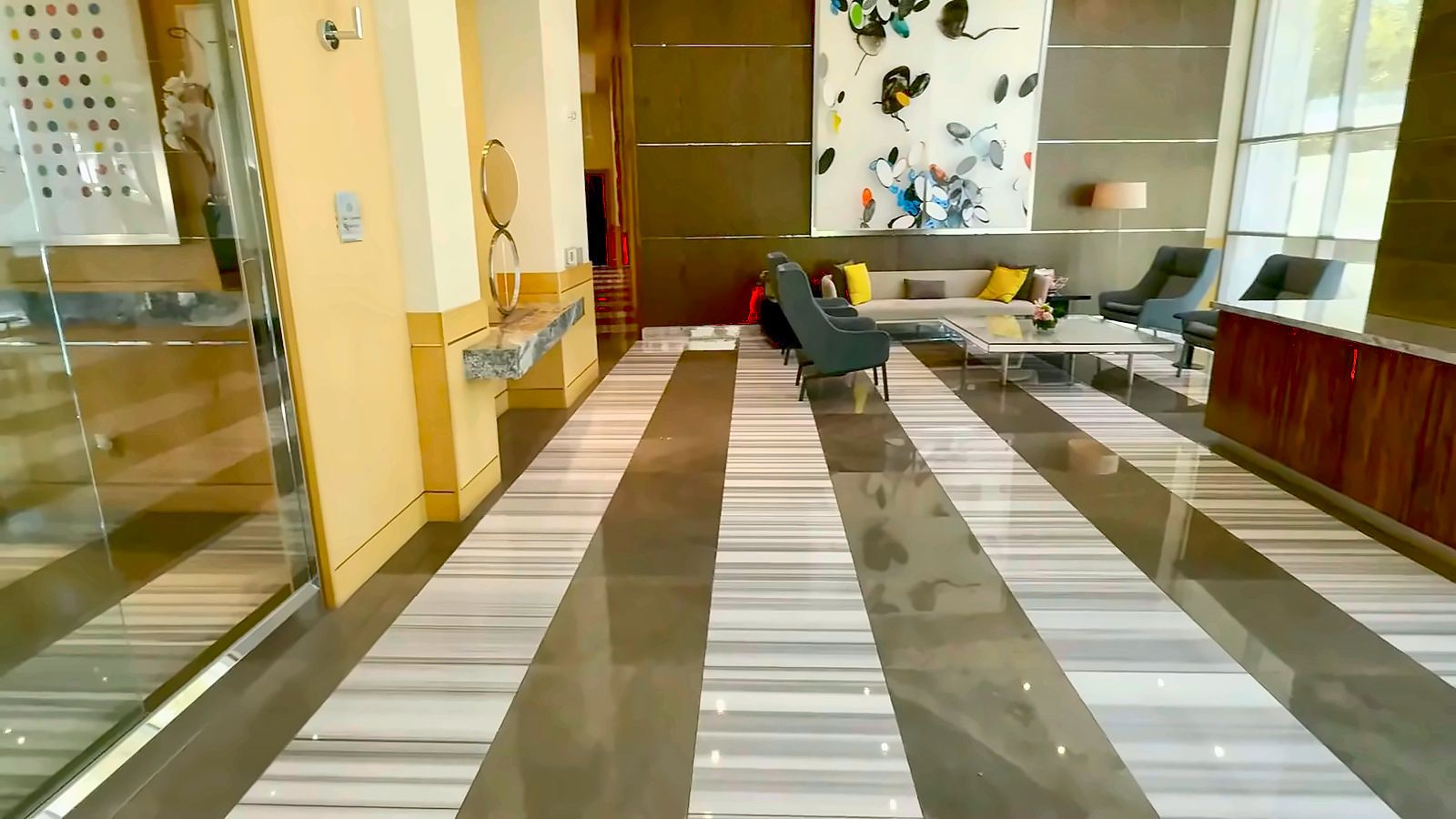Turnberry Towers residents' lobby lounge with striped marble floors, seating and floor-to-ceiling windows