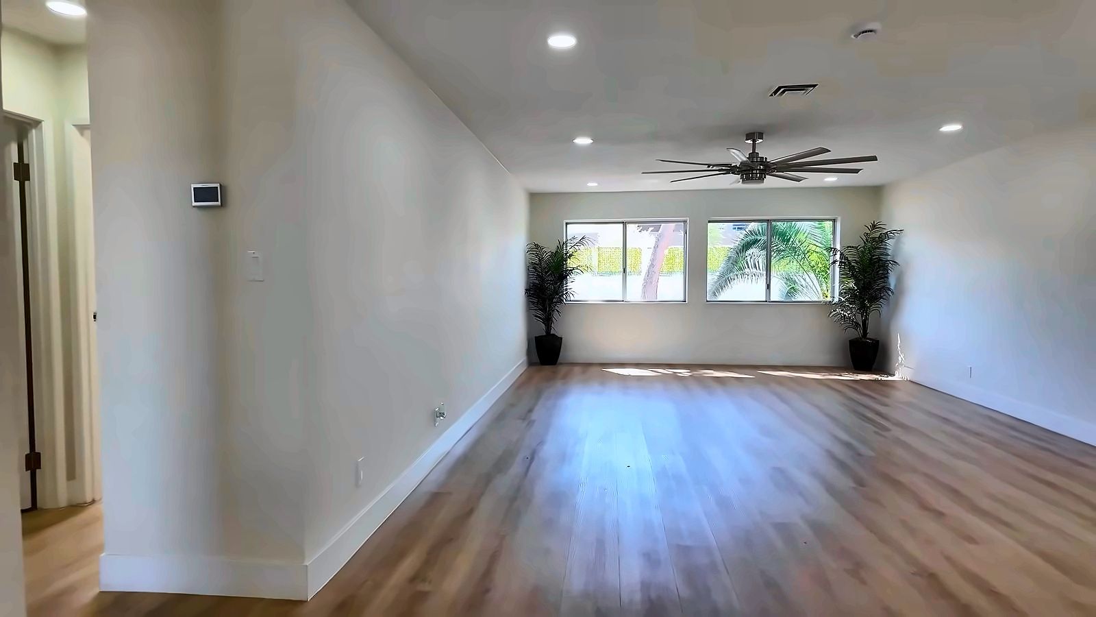 Remodeled open living area in a Las Vegas resale home with wood-look flooring and a ceiling fan