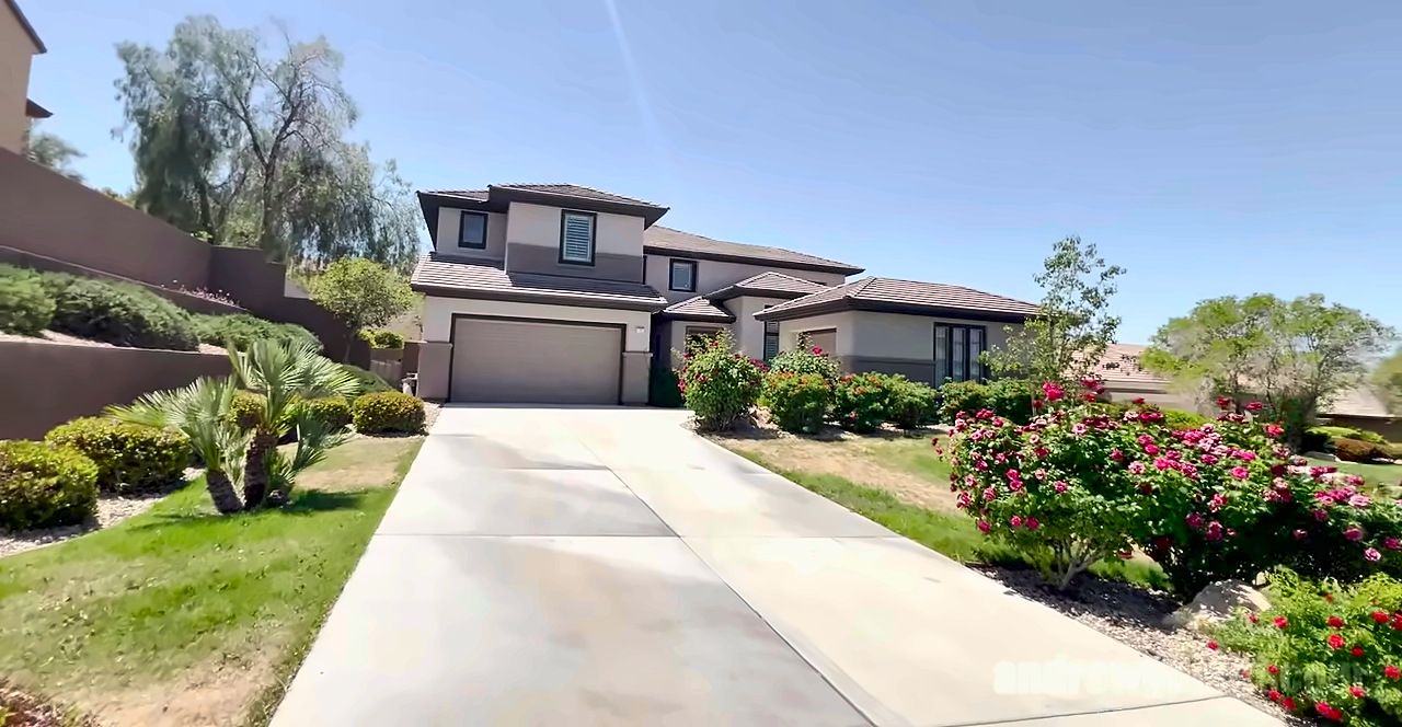 Two-story stucco homes with tile roofs and landscaped yards on a street in Anthem Country Club, Henderson