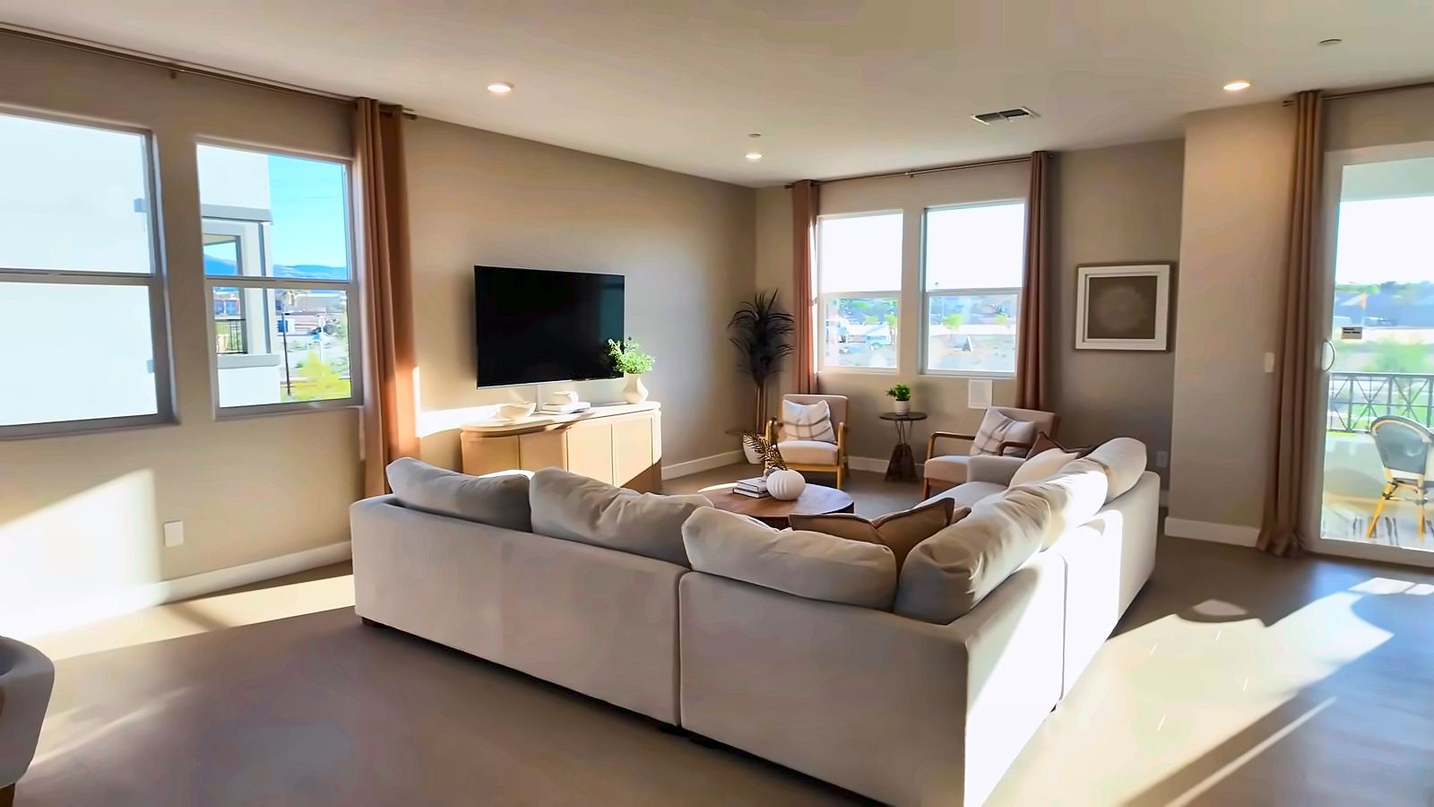 Living room in the KB Home 2320 three-story model at Peaks at Meriden with a sectional sofa and large windows