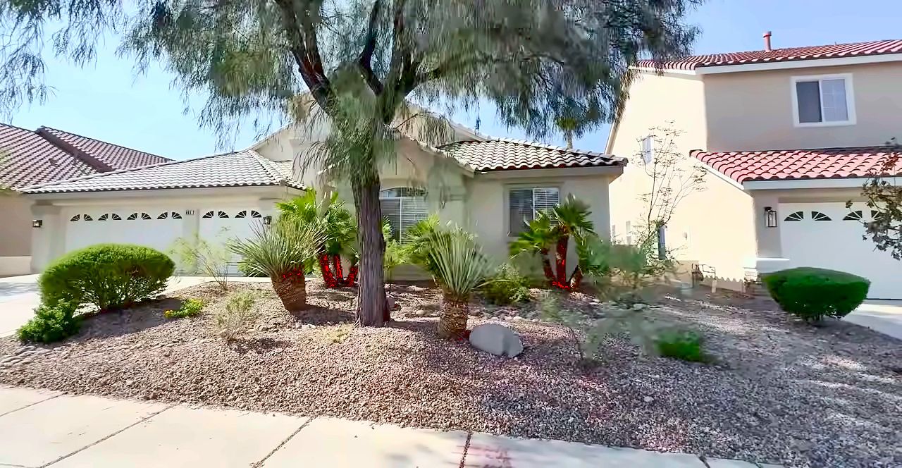 Single-story Green Valley homes with gravel desert landscaping and a mature tree in Henderson, NV 89052