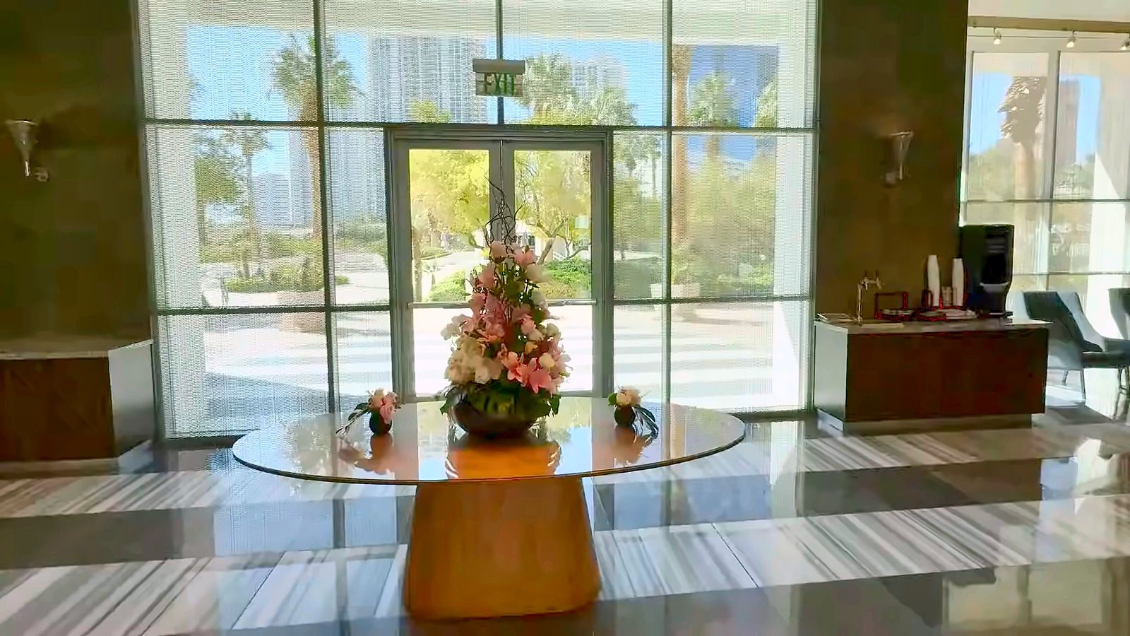 Turnberry Towers lobby entrance with glass doors, a round flower table and the front desk