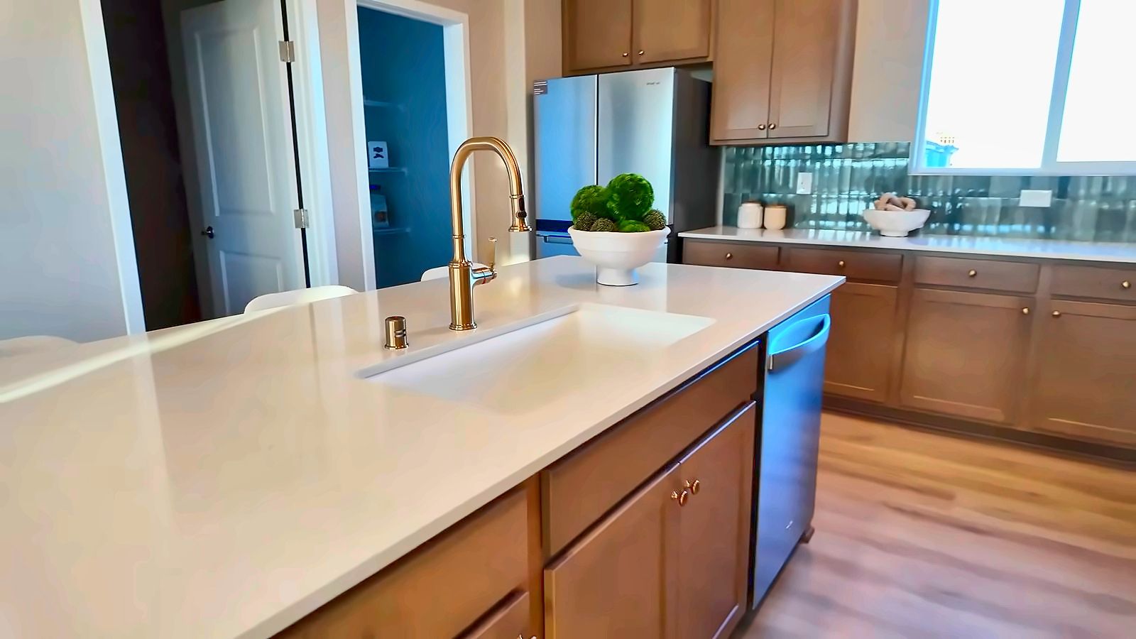 Kitchen in the KB Home 1947 townhome model at Avenues at Meriden with a white quartz island, wood cabinets, and stainless appliances