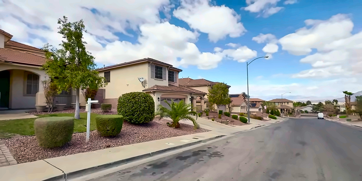 Two-story homes with tile roofs and trimmed shrubs on a Green Valley Ranch street in Henderson, NV 89012