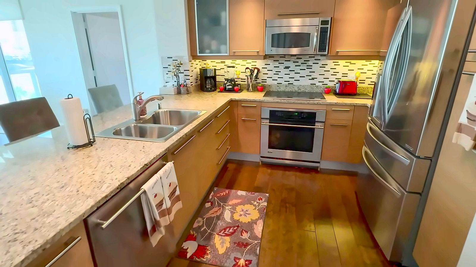 Kitchen with stainless steel appliances, granite counters and a mosaic tile backsplash in a Turnberry Towers condo