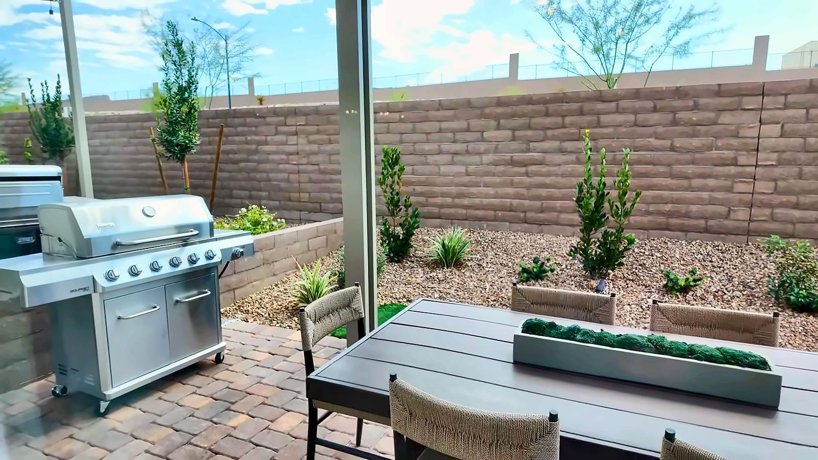 Backyard of the Pulte Camelia model with a paver patio, outdoor grill, and block wall