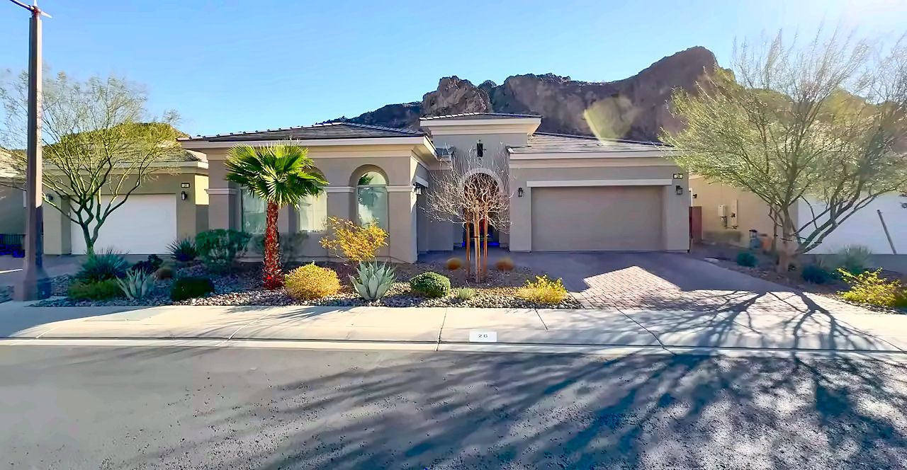 Single-story Lake Las Vegas home with a tile roof, palm tree and a rugged desert mountain behind it