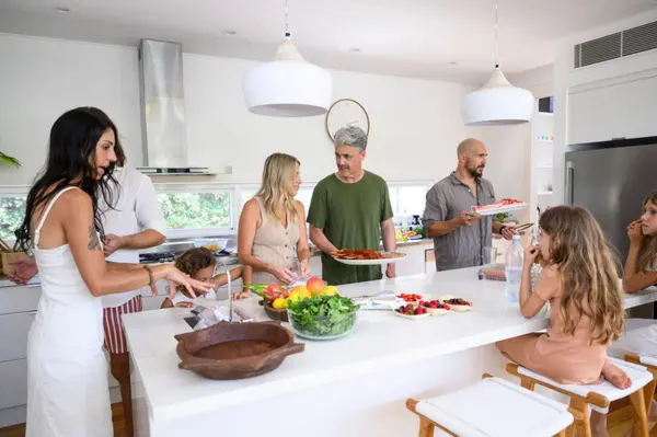 Family members standing and sitting around kitchen island