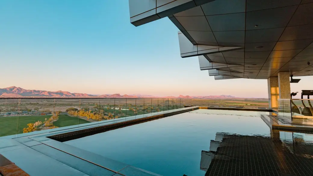 Infinity pool overlooking the Sonoran Desert and distant mountains at sunset