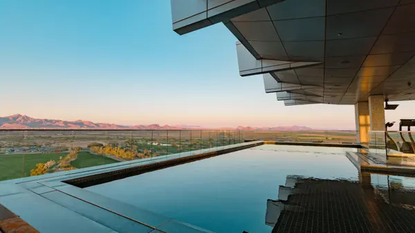 Infinity pool overlooking the Sonoran Desert and distant mountains at sunset