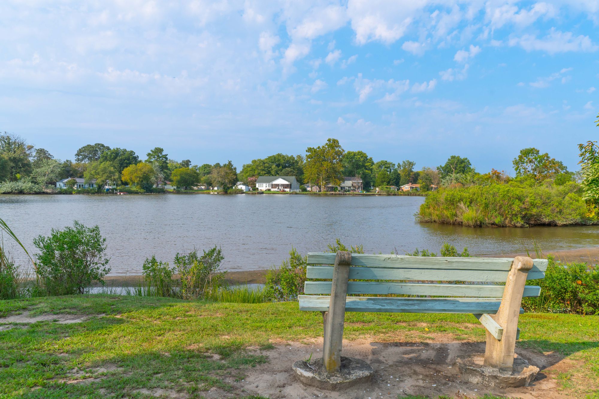 Scenic view of a private community beach and boat launch ramp at Golden Beach, Maryland, with residents enjoying the shoreline and a wooden pier