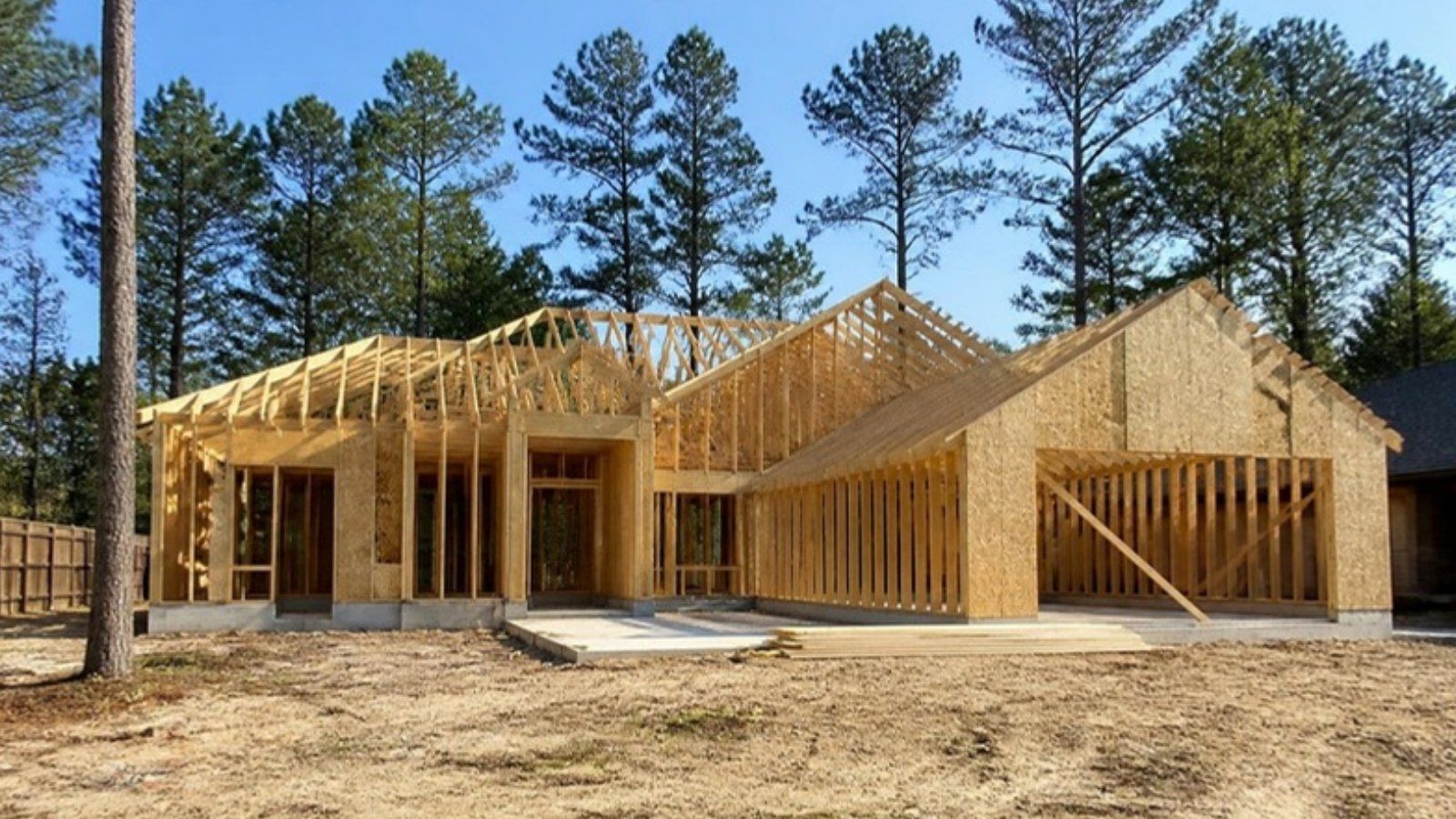 New home under construction among tall pine trees in Cypress, TX