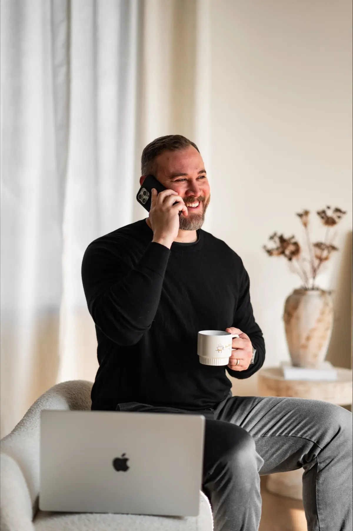 Matt Martin holding a cup of coffee while taking phone calls