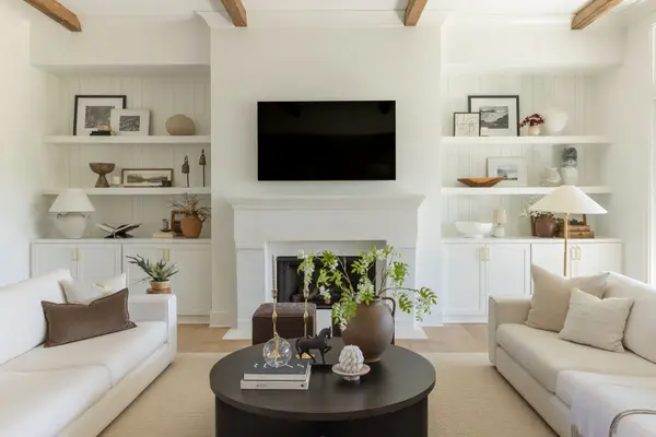 Modern living room with custom shelving and fireplace.