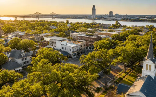 Aerial view of leafy Greater Baton Rouge suburbs and small-town main streets at golden hour