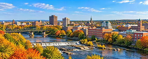 Autumn Riverfront Cityscape with Waterfall