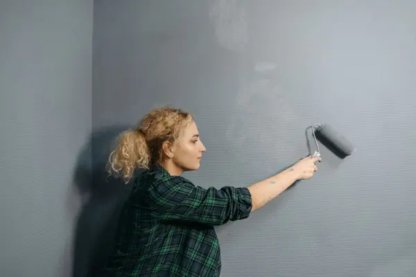 Homeowner painting a wall while preparing a home for sale