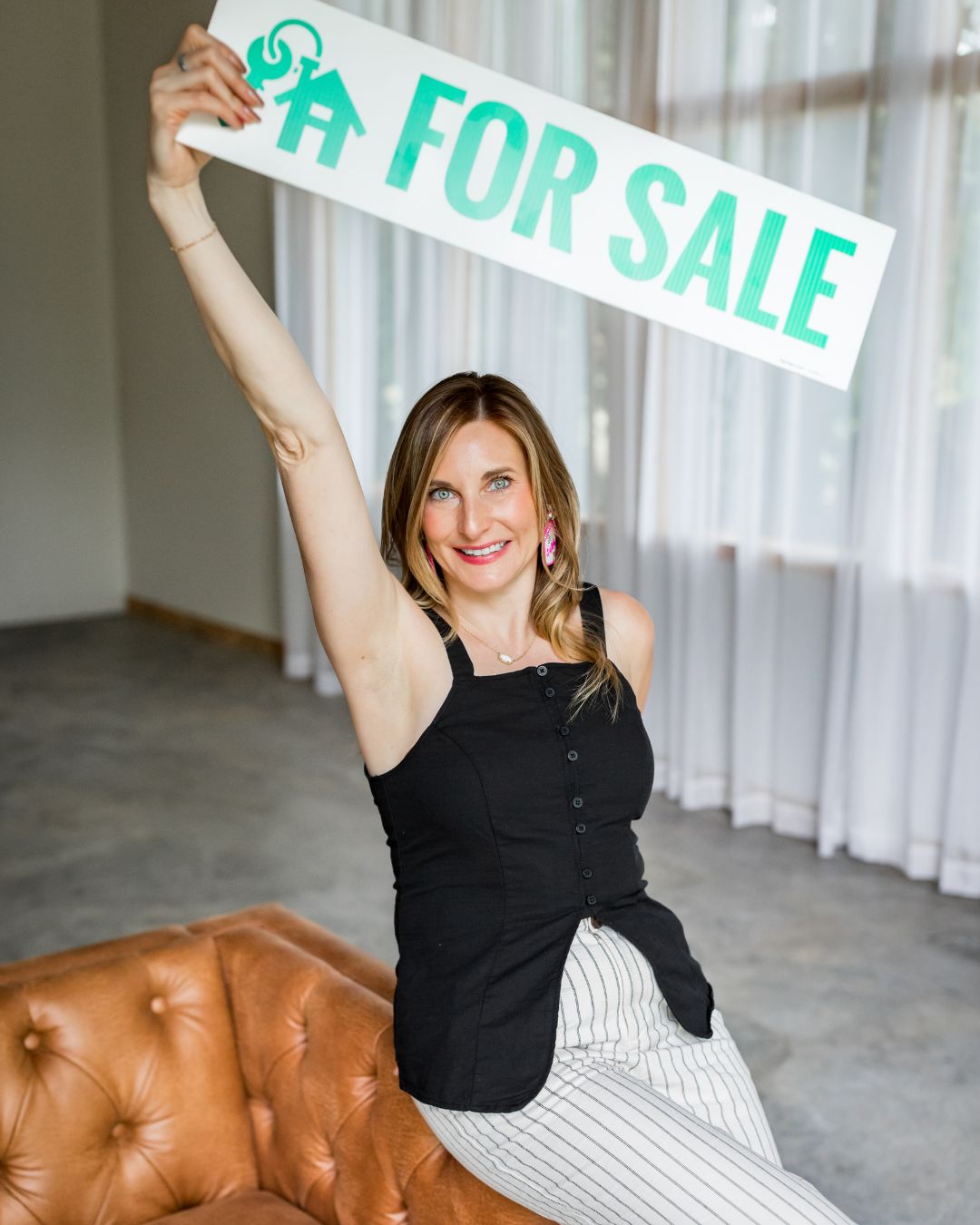 Jennifer Moran, Realtor, with a For Sale sign
