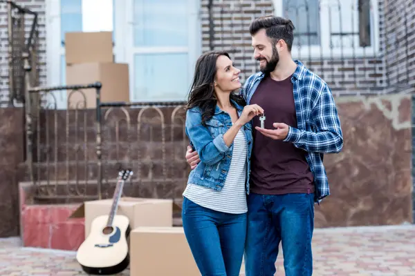 cheerful-couple-holding-keys-in-front-of-new-house-2026-09-22-21-18-31-utc
