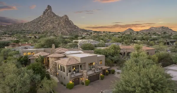 Desert home at sunset with a mountain peak behind it