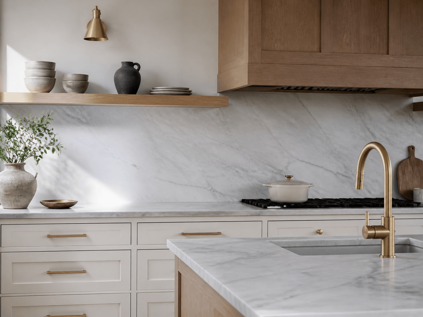 Custom kitchen with marble counters, millwork and brass hardware