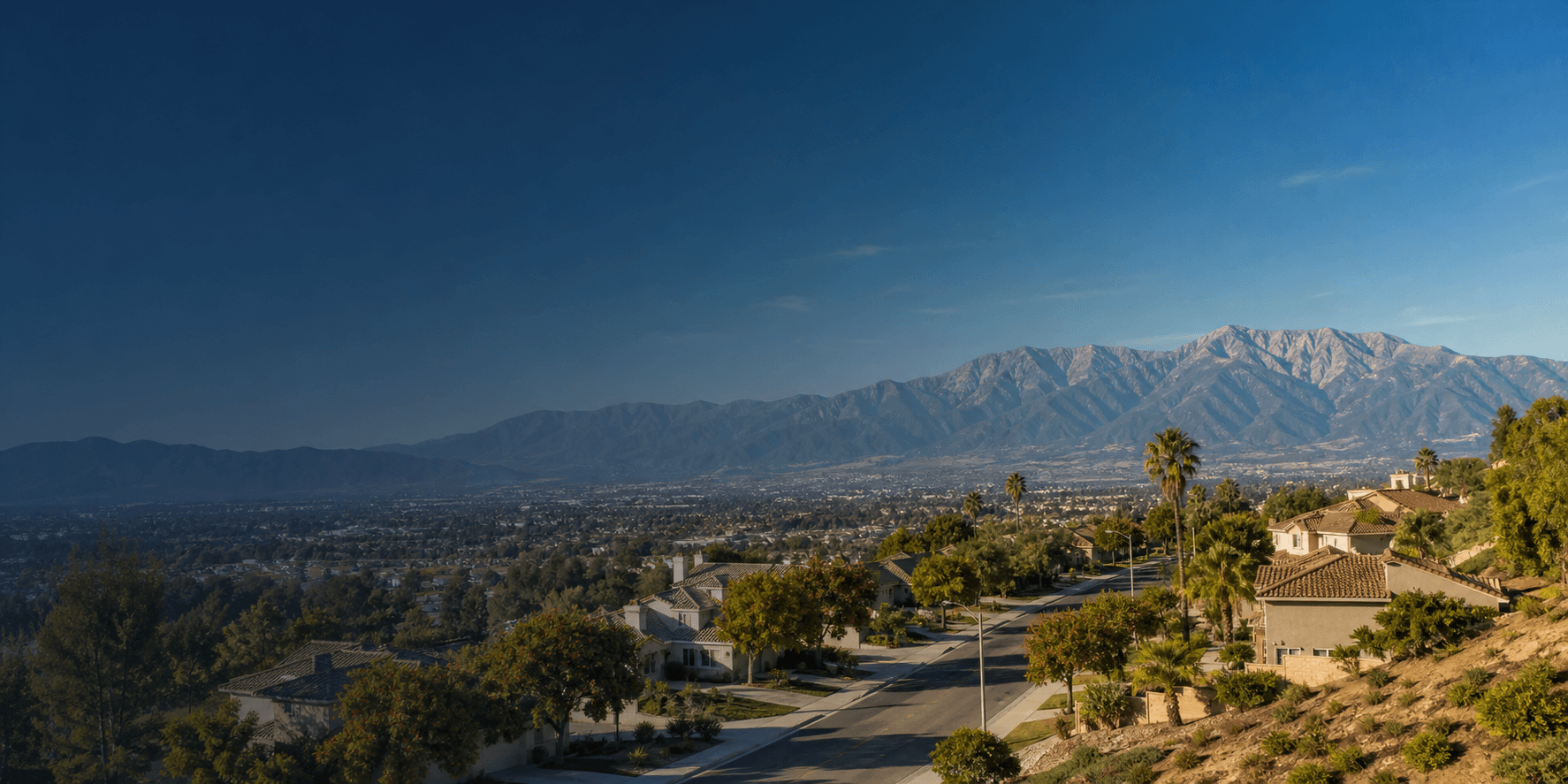 Wide panoramic view of Inland Empire suburban neighborhoods with the San Bernardino mountain range on the horizon
