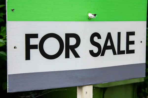 For Sale sign in front of a home