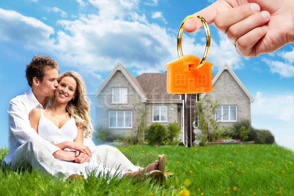 Pareja feliz frente a su nueva casa