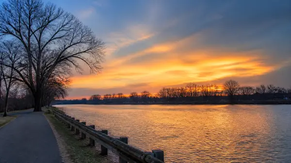 River at sunset with bare trees and a riverside path